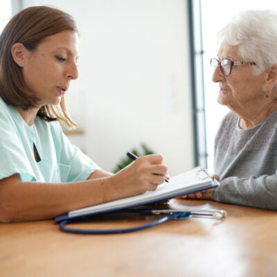 Nurse giving prescription to elderly woman